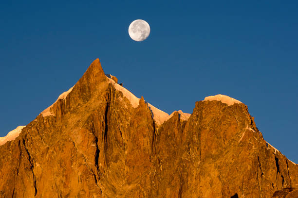 istock moon over mont blanc du Tacul at sunrise with red mountains 1060592720
