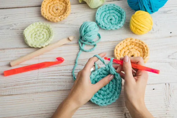 Photo of woman hands knitting crochet.