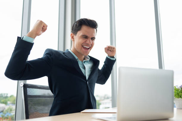 istock Businessman is celebrating with arms up while working on Laptop computer. 1060599516