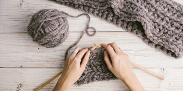 Photo of Female hands in the process of knitting.