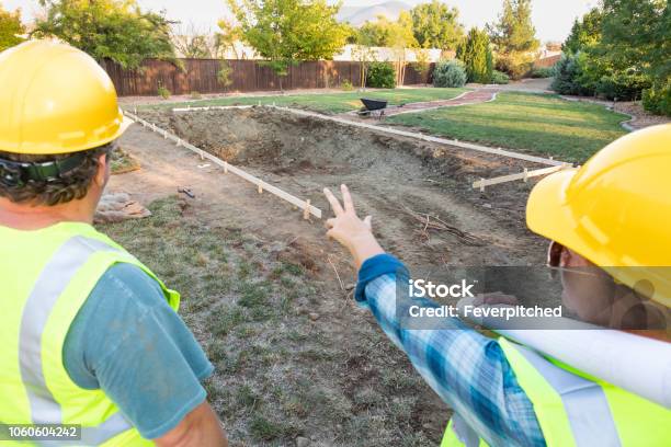 Male And Female Workers Overlooking Pool Construction Site Stock Photo - Download Image Now