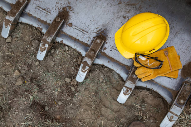 Hardhat, Gloves and Protective Glasses Resting on Bulldozer Bucket Abstract stock photo