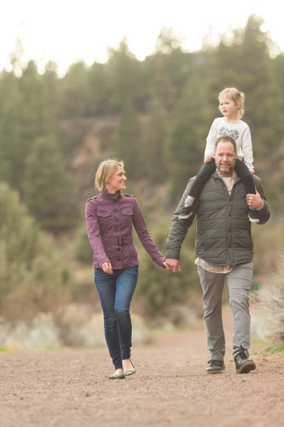 istock Middle-aged parents holding hands as they go on a hike with their daughter 1060605664