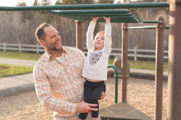 istock Dad teaches his daughter how to swing on the monkey bars 1060605666