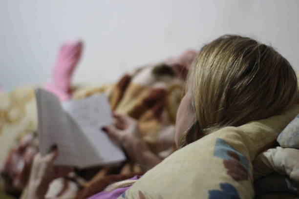 istock Woman reading book in bed 1060606220