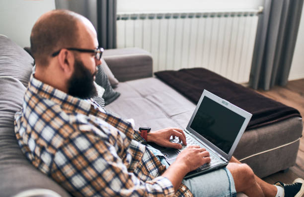 istock Bearded man with laptop working at home 1060609912