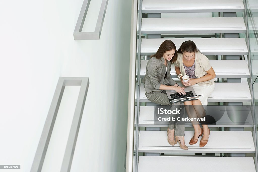 Деловых используя ноутбук на лестнице - Стоковые фото 25-29 лет роялти-фри