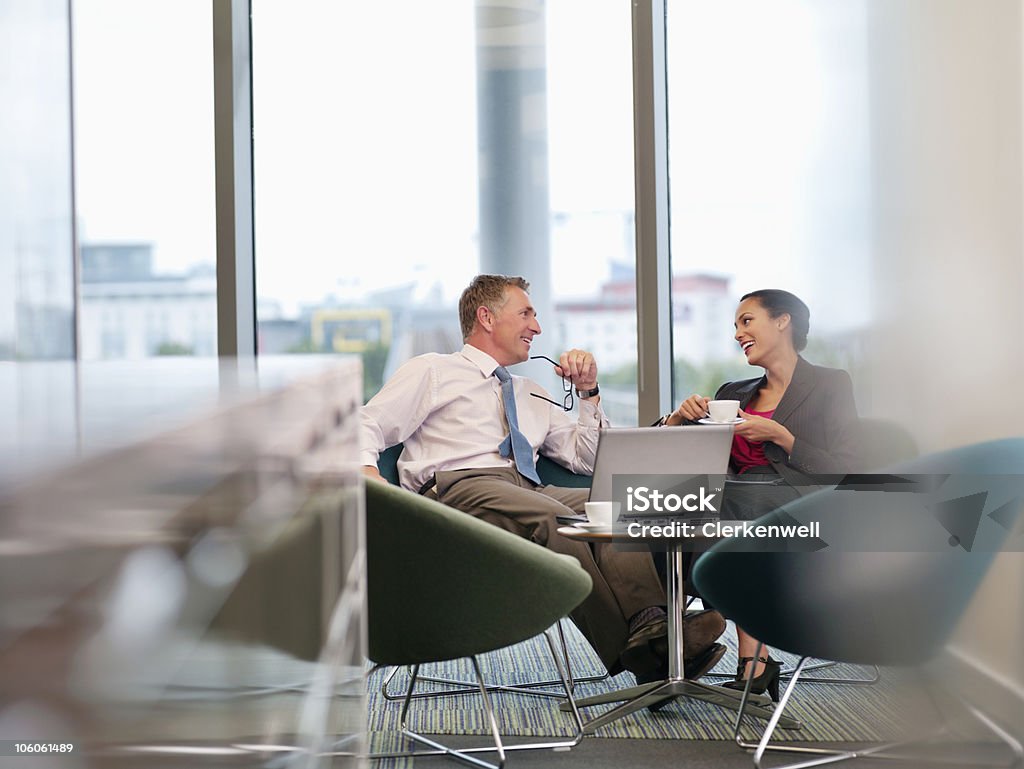 Dwóch ludzi biznesu w biurze conversing stołówce - Zbiór zdjęć royalty-free (Laptop)