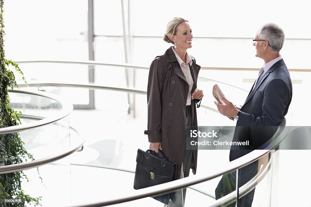 Colleghi di lavoro felice avere una comunicazione in aeroporto - Foto stock royalty-free di 40-44 anni