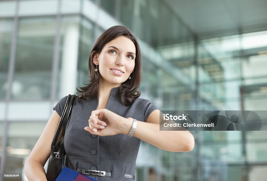 Businesswoman looking at watch in airport  Anticipation Stock Photo