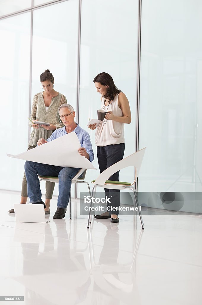 Office workers discussing on blueprint in office  25-29 Years Stock Photo