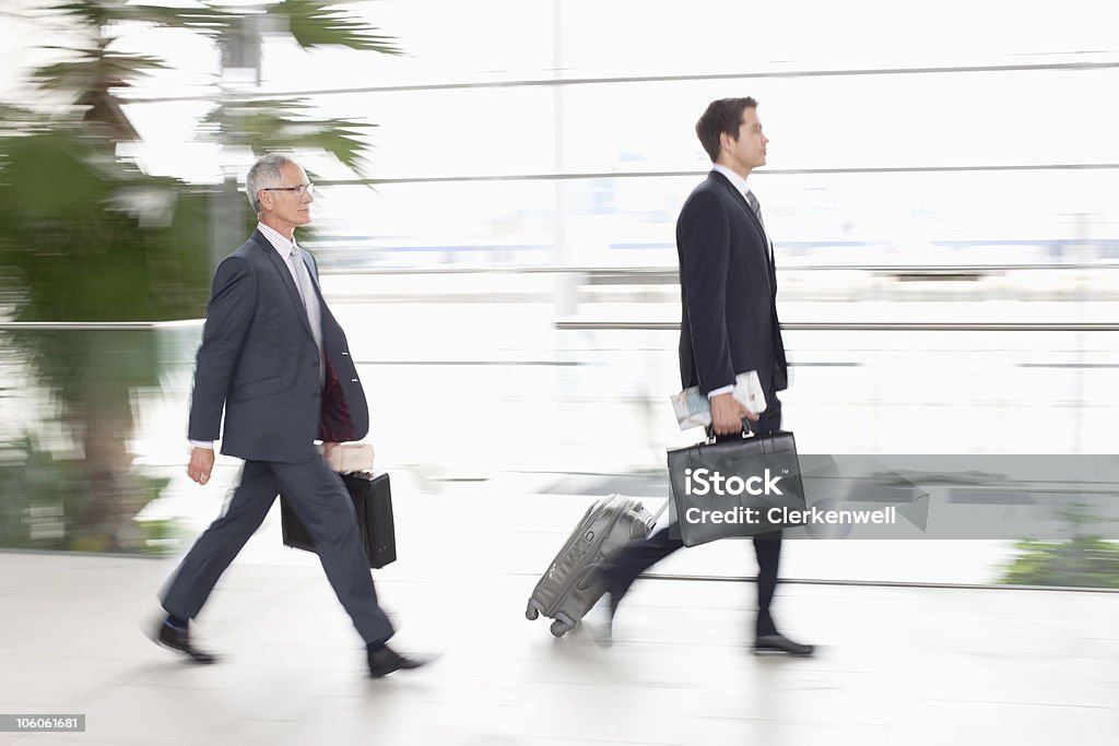 Due dirigenti con i bagagli, vista laterale - Foto stock royalty-free di Baby Boomer