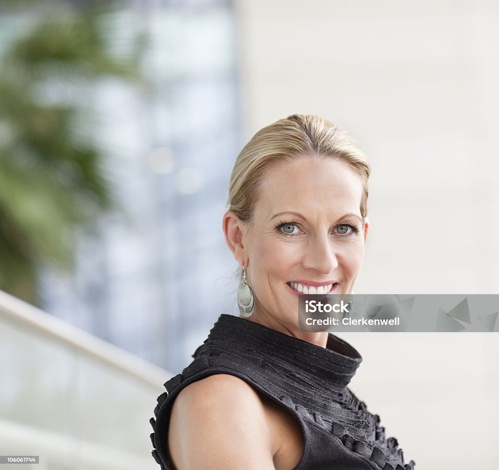 Ritratto di una donna d'affari sorridente in ufficio - Foto stock royalty-free di Orecchini