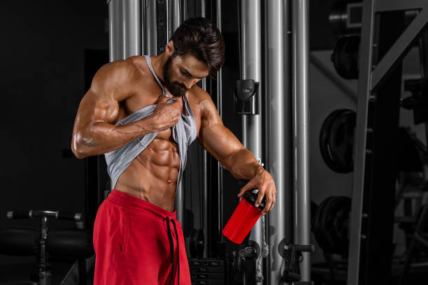 Abdominal Muscle Muscular Men Checking his Abdominal Muscles bodybuilding supplement stock pictures, royalty-free photos & images