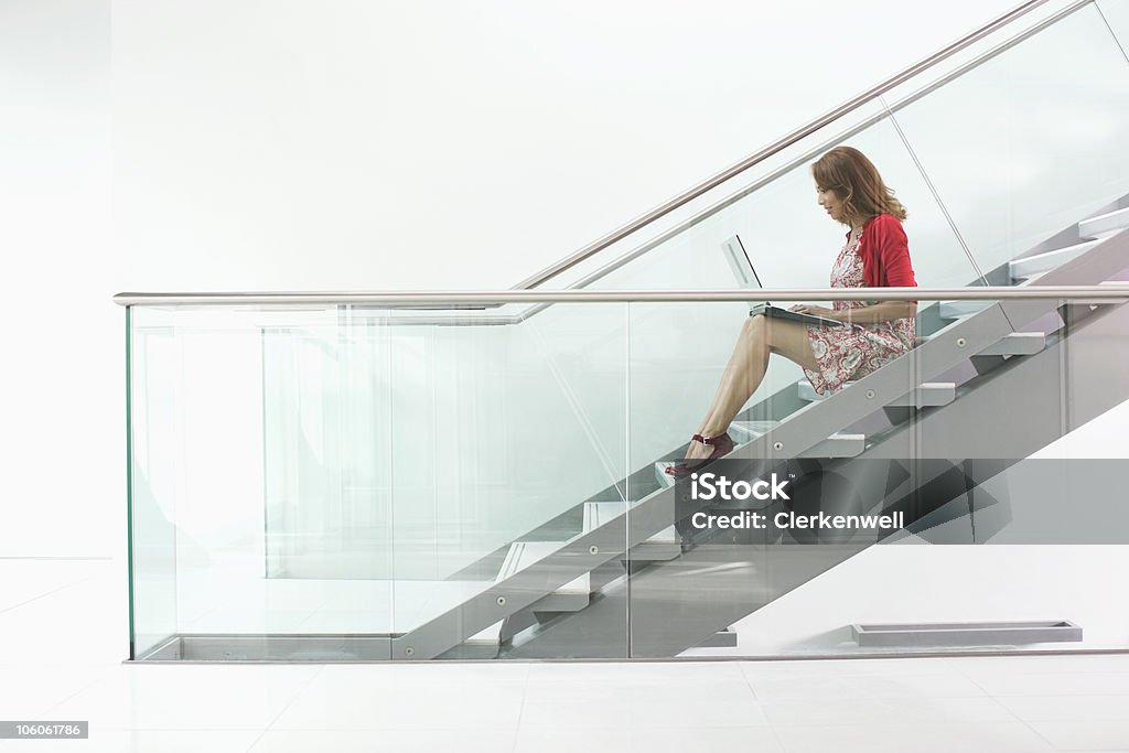 앉아 있는 여성 계단 및 사용하여 노트북, 측면 보기 - 로열티 프리 여자 사업가 스톡 사진