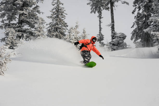 istock Man running down the mountain slope on the snowboard 1060617946