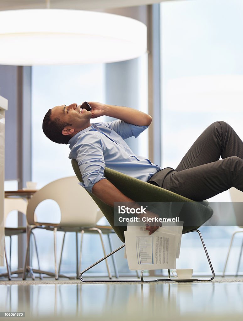 Biznesmen na telefon w biurze odpoczynku, widok z boku - Zbiór zdjęć royalty-free (Biznesmen)