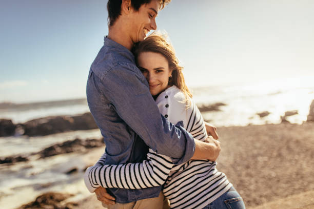 istock Happy couple hugging each other standing at the beach 1060620488