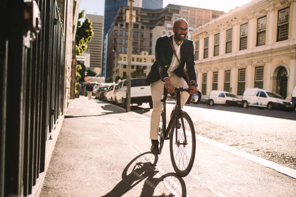 homme d’affaires souriant, aller au travail en vélo - cycling cyclist bicycle men photos et images de collection