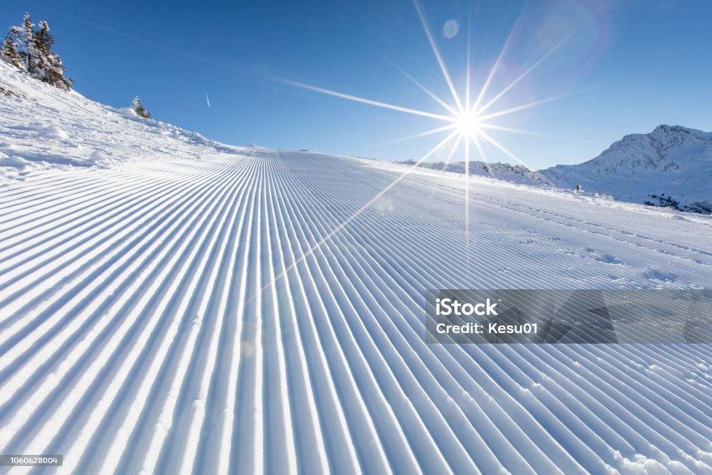 Fresh snow on ski slope during sunny day. Fresh snow on ski slope during sunny day, Alps mountains. Ski Slope Stock Photo