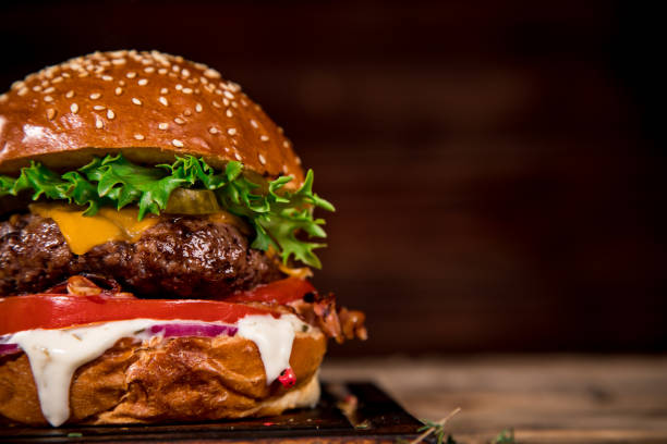 istock Tasty burger on wooden table. 1060628158