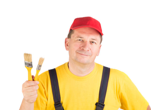 istock Worker shows painting brush. 1060628292