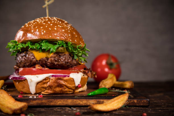 istock Tasty burger on wooden table. 1060628360