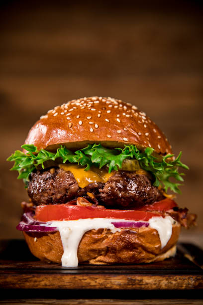 istock Tasty burger on wooden table. 1060628446