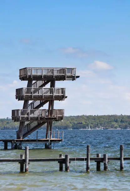 A series of diving boards stretching above the blue water of lake Ammersee in the town of Utting