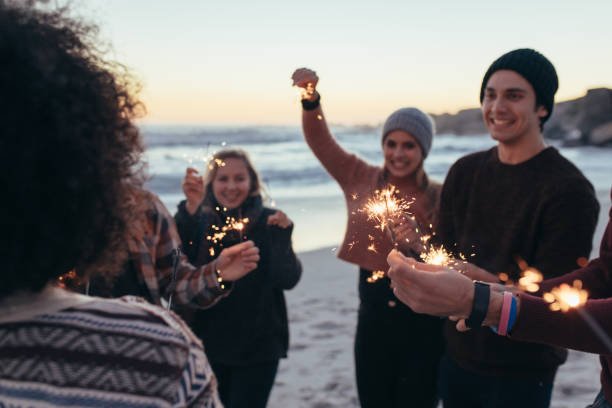 istock Young people having fun with sparklers at beach 1060630628