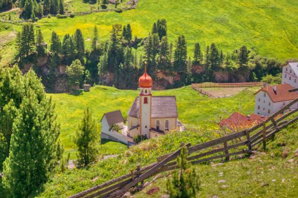istock Tyrolean church and sunny valley with blooming meadows 1060631452