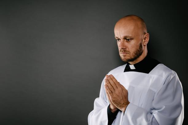 istock Catholic priest in white surplice prays 1060632712