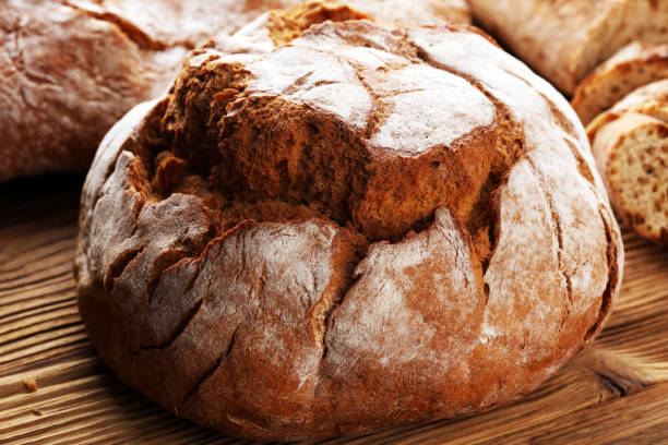 istock Different kinds of bread and bread rolls on board from above. Kitchen or bakery 1060633190