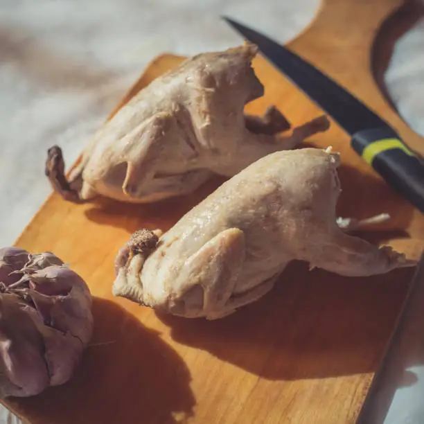 Photo of Two whole boiled quails lie on a cutting board as an example of diet food