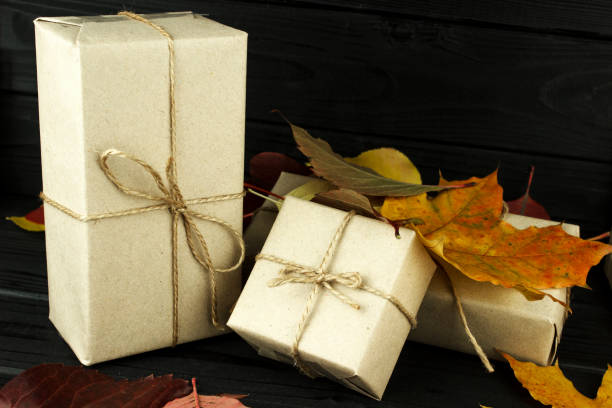 istock copy spase, three gift boxes in the fall leaves are colored, on a dark village background 1060636678