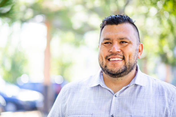 Portrait of a hispanic man A young hispanic man smiles outdoors fat mexican man pictures stock pictures, royalty-free photos & images