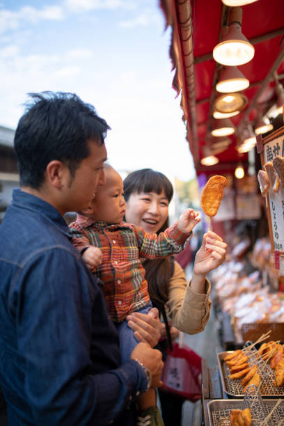 istock Young family holding Osenbei - Japanese rice cracker 1060648770