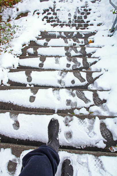 eine frau will eine rutschige treppe hinunter zu gehen, im winter - sidewalk walking human foot city stock-fotos und bilder