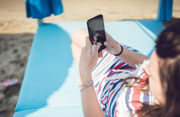 istock Young woman using phone on the beach 1060652644