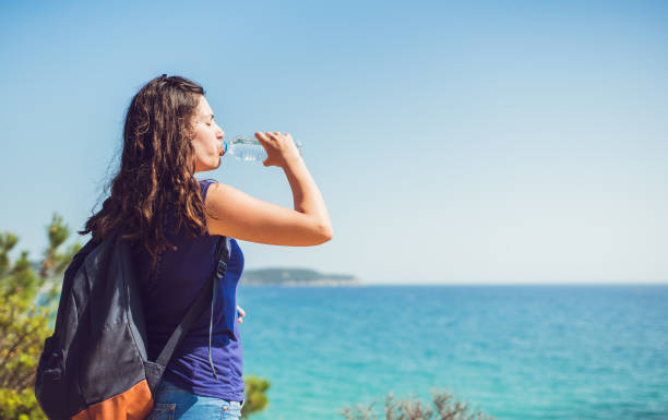 istock Woman drinking water at seaside viewpoint 1060652792