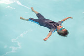 かわいい小さなアジア 30 ヶ月/2 歳幼児赤ちゃんの少年は、水泳授業で泳ぎを習う