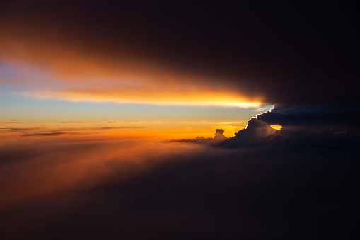 An aerial view of a thunderstorm at sunset above Kansas. The storm clouds block the sun creating a dramatic shadow and silver lining