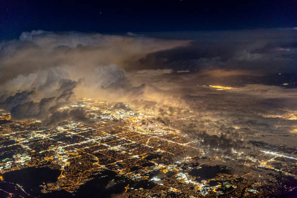 An aerial view of Denver at night with a thunderstorm above the city