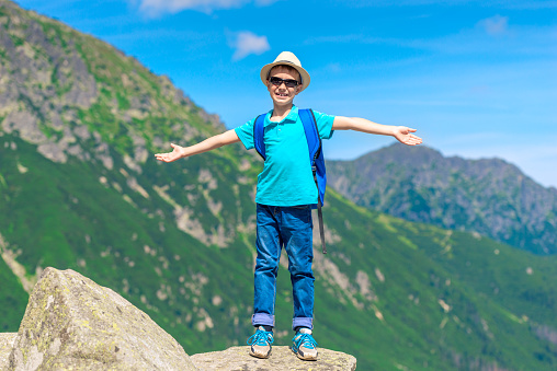 Teenage boy in the mountains. A boy on top of the mountain in rainy weather.