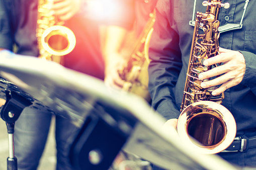 Festival de Jazz del mundo. Saxofón, instrumento musical interpretado por el saxofonista jugador y banda de músicos en el escenario de la fiesta. photo