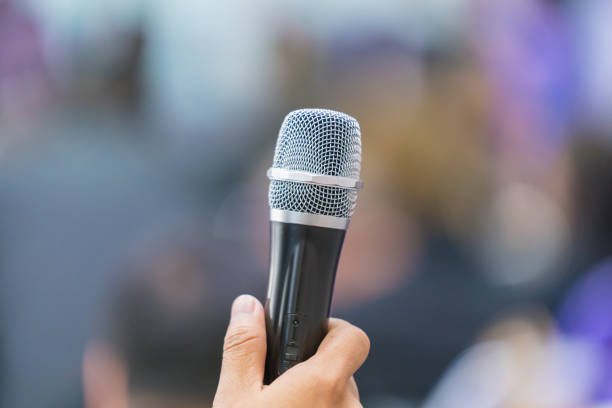 istock hand hold Microphone in meeting room for a conference 1060669844