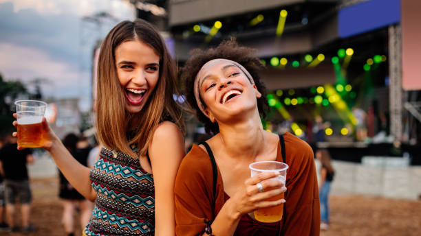 They always have a blast together! Cropped shot of two young female friends at a music festival beer alcohol stock pictures, royalty-free photos & images