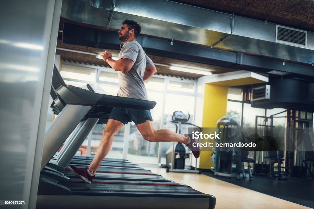 Working on his condition Male running on treadmill at the gym Gym Stock Photo