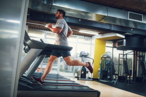 Working on his condition Male running on treadmill at the gym cardiovascular exercise stock pictures, royalty-free photos & images