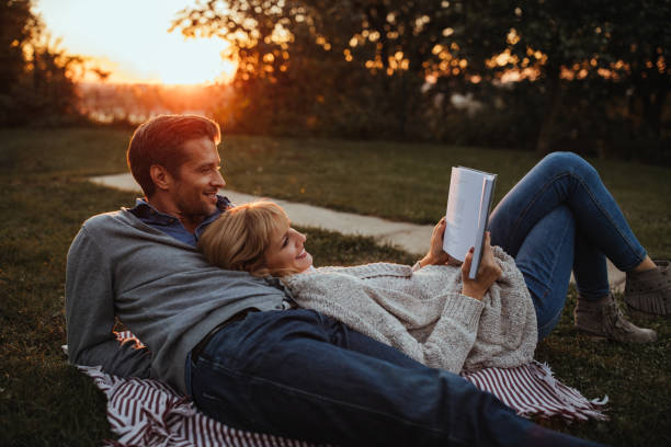 Adorable couple outdoors Husband and wife reading a book outdoors Petrovaradin stock pictures, royalty-free photos & images